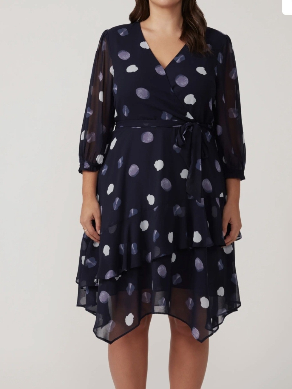 The Estelle Plus Begin Again Dress features an asymmetric hem and a tie detail.